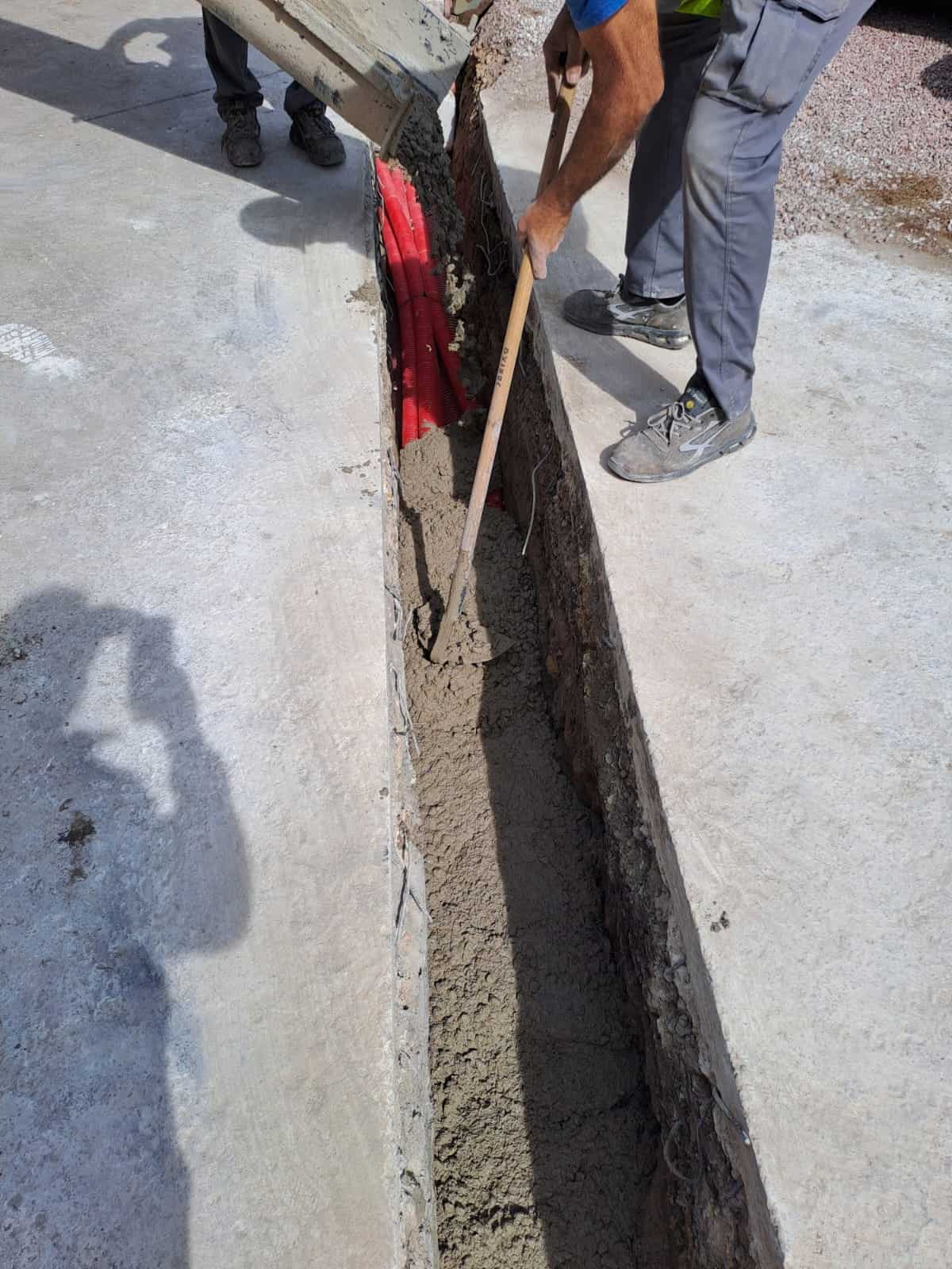 Obrero echando hormigon zanja