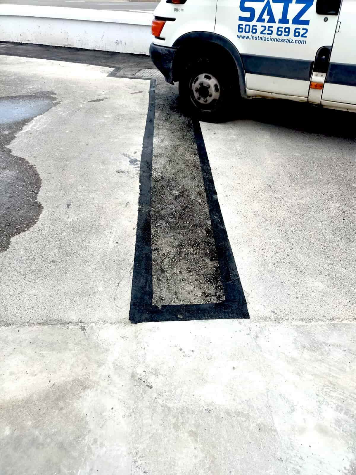 Parcheo de asfalto en acceso vial junto a instalaciones eléctricas