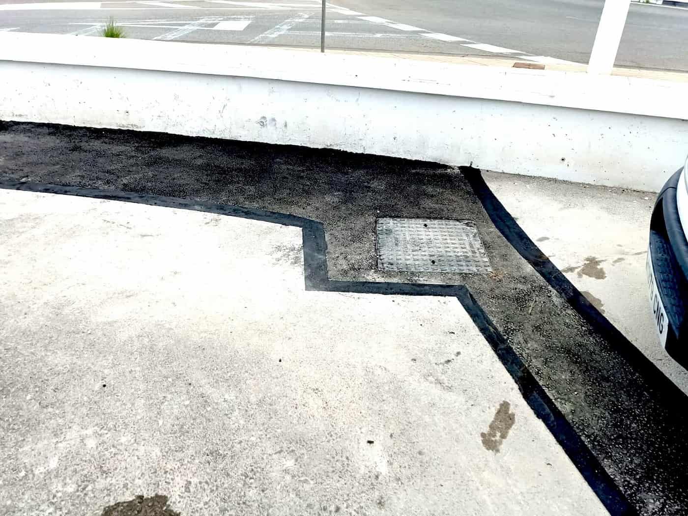Reparación de pavimento con parcheo de asfalto en área de estacionamiento